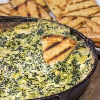 Looking for a fun appetizer recipe with an outdoor smoky twist? Fire up the grill or smoker and make a batch of this Smoked Spinach Artichoke Dip!