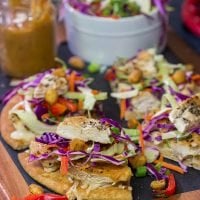 These Thai Chicken Flatbreads are a fun and colorful appetizer or main course! They get topped with a tasty peanut sauce for extra flavor.