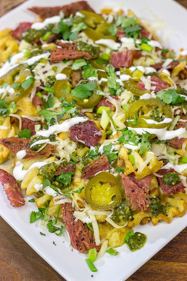 Get into the St. Patrick's Day spirit with a batch of these Irish Nachos - waffle fries loaded with cheese, salsa verde and chopped corned beef!