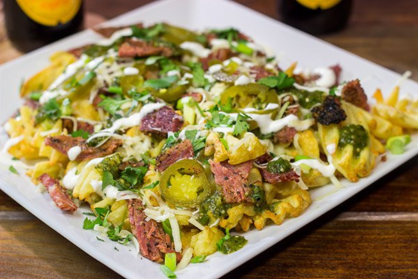 Get into the St. Patrick's Day spirit with a batch of these Irish Nachos - waffle fries loaded with cheese, salsa verde and chopped corned beef!