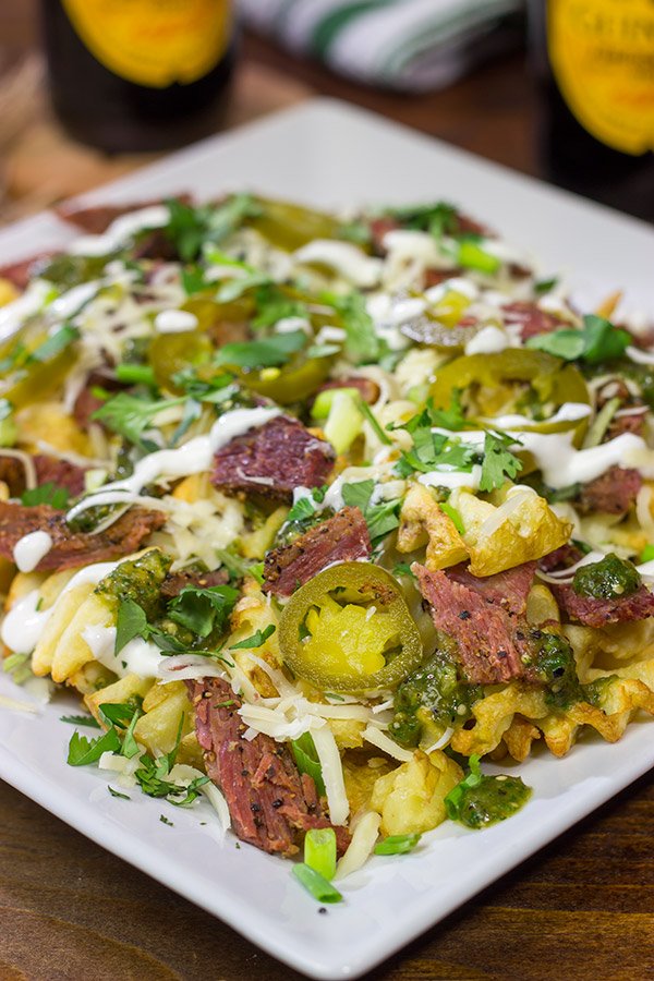 Get into the St. Patrick's Day spirit with a batch of these Irish Nachos - waffle fries loaded with cheese, salsa verde and chopped corned beef!