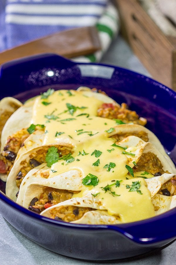 Want to break out of the 'dinner rut'?  Then put these Cheesy Baked Burritos on the menu!  Topped with an easy, homemade cheese sauce, these burritos are the perfect comfort food for chilly days!