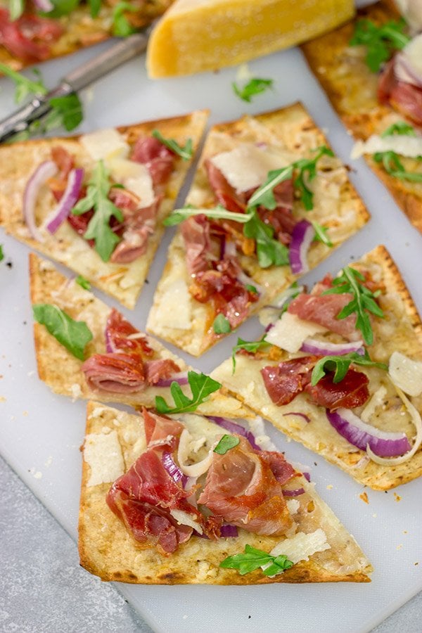 This Crispy Prosciutto Flatbread makes for a great heavy appetizer or light lunch.  It tastes even better served with a glass of wine and good company!