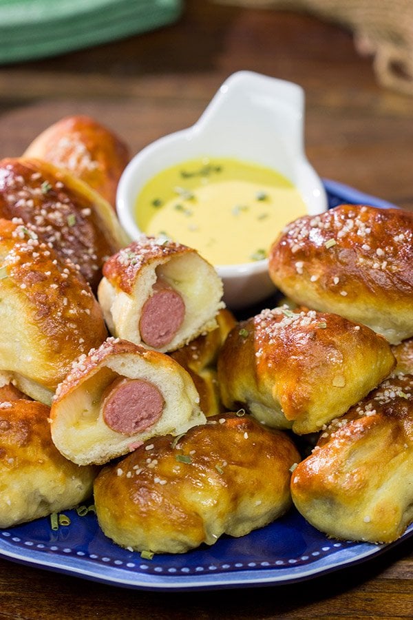Take the classic pigs in a blanket to a new level...by adding cheese and then wrapping them in pretzel dough! Serve these Pretzel Pigs in a Blanket with a quick and easy honey mustard dipping sauce for extra flavor!