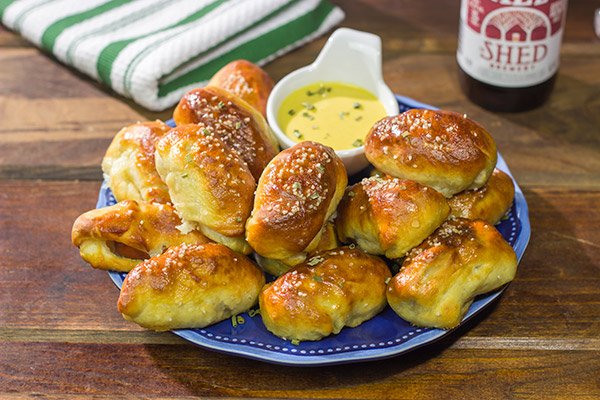 Take the classic pigs in a blanket to a new level...by adding cheese and then wrapping them in pretzel dough! Serve these Pretzel Pigs in a Blanket with a quick and easy honey mustard dipping sauce for extra flavor!