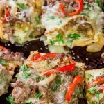 Combine two favorites into one with this Philly Cheesesteak Garlic Bread - shaved steak, peppers + onions, melted cheese...all on top of buttery, garlicky bread!
