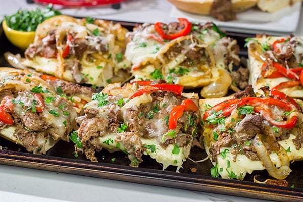 Combine two favorites into one with this Philly Cheesesteak Garlic Bread - shaved steak, peppers + onions, melted cheese...all on top of buttery, garlicky bread!