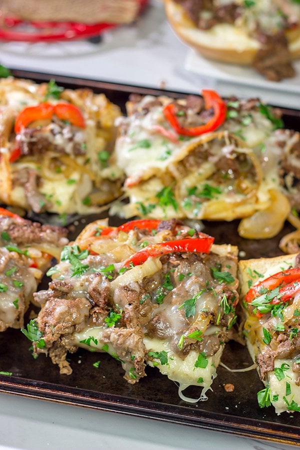 Combine two favorites into one with this Philly Cheesesteak Garlic Bread - shaved steak, peppers + onions, melted cheese...all on top of buttery, garlicky bread!