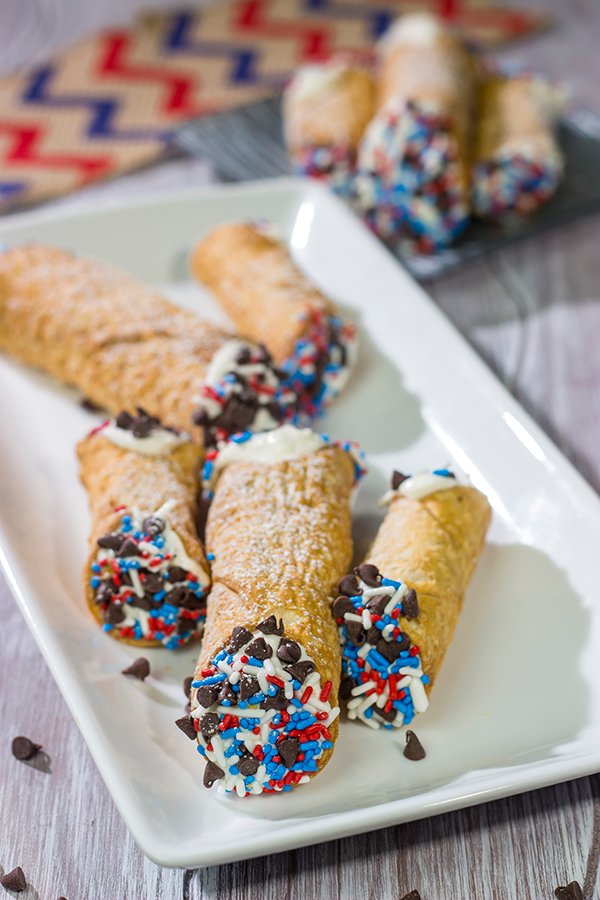These Red White and Blue Cannoli make for a festive and tasty 4th of July dessert!  (Hint: Using store-bought cannoli shells makes this recipe super easy!)