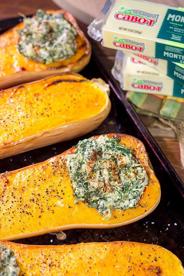 Looking for a fun Autumn recipe?  Then put this Spinach Artichoke Stuffed Squash on the menu.  Buttery roasted squash combined with creamy spinach artichoke filling makes for a tasty fall meal!