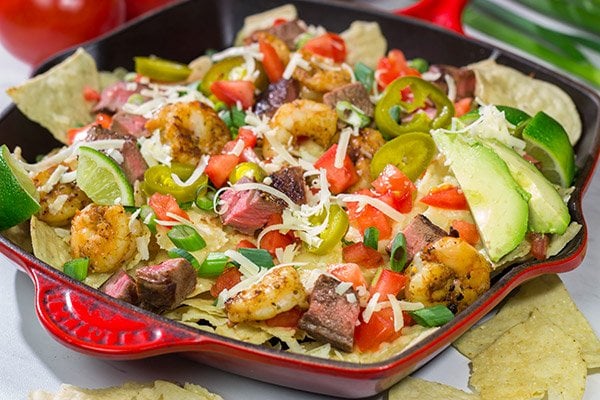 Put a comfort food spin on a classic restaurant favorite.  These Surf and Turf Nachos are topped with juicy steak and flavorful shrimp - whip up a batch for dinner this weekend!