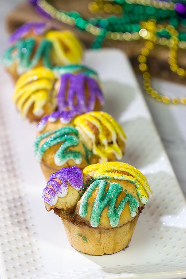 Celebrate Mardi Gras with a batch of these Muffin Tin King Cakes!  Filled with cinnamon + brown sugar flavor, these king cakes make for a festive treat!