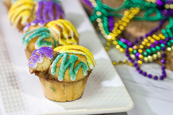 Celebrate Mardi Gras with a batch of these Muffin Tin King Cakes!  Filled with cinnamon + brown sugar flavor, these king cakes make for a festive treat!