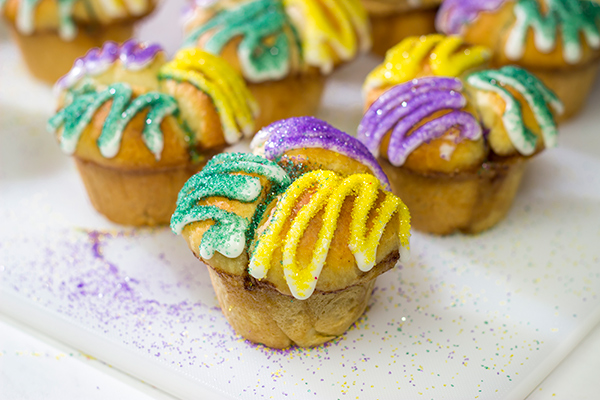 Celebrate Mardi Gras with a batch of these Muffin Tin King Cakes!  Filled with cinnamon + brown sugar flavor, these king cakes make for a festive treat!