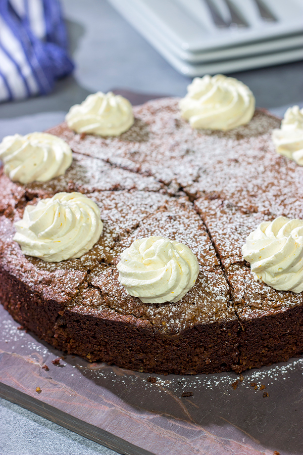 Packed with chocolate and chopped almonds, this Torta Caprese makes for a delicious treat...especially when topped with a dollop of orange-ginger whipped cream!