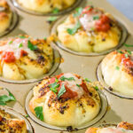 This Meatball Stuffed Garlic Bread features meatballs wrapped in pizza dough and baked in a muffin tin.  It's a fun dinner recipe, or it could also work as an appetizer!