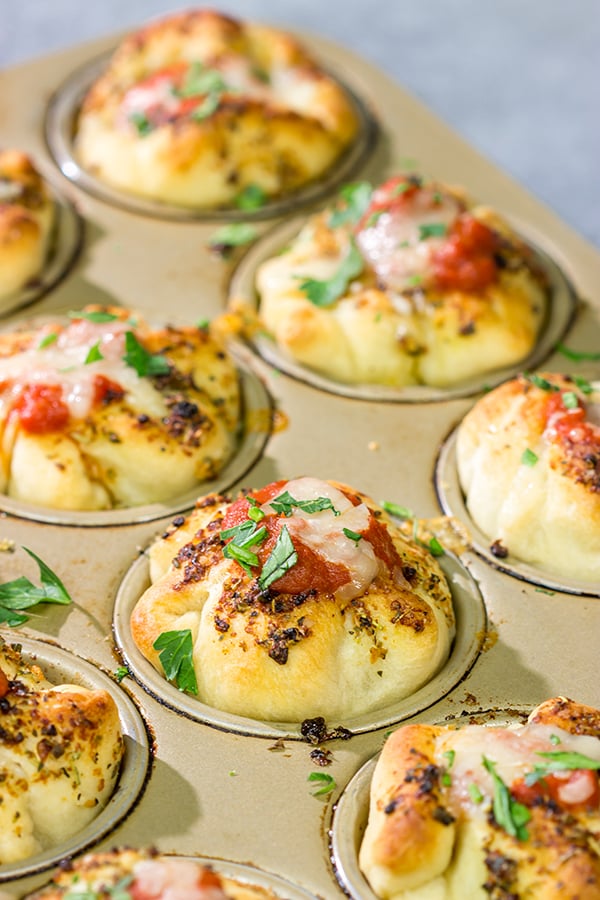 This Meatball Stuffed Garlic Bread features meatballs wrapped in pizza dough and baked in a muffin tin.  It's a fun dinner recipe, or it could also work as an appetizer!