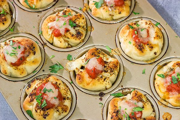 This Meatball Stuffed Garlic Bread features meatballs wrapped in pizza dough and baked in a muffin tin. It's a fun dinner recipe, or it could also work as an appetizer!