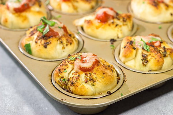 This Meatball Stuffed Garlic Bread features meatballs wrapped in pizza dough and baked in a muffin tin. It's a fun dinner recipe, or it could also work as an appetizer!