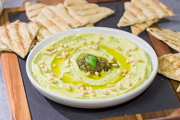 Looking for a fun and tasty summer appetizer? Whip up a batch of Basil Pesto Hummus! This recipe is great to serve when hanging out with friends on the back porch!