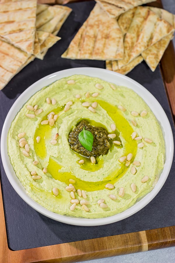 Looking for a fun and tasty summer appetizer? Whip up a batch of Basil Pesto Hummus! This recipe is great to serve when hanging out with friends on the back porch!