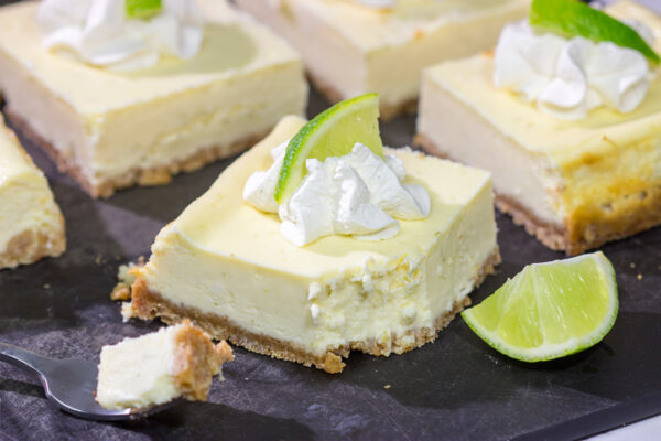 Featuring a hint of tequila + lime flavor in a creamy cheesecake filling, these Margarita Cheesecake Bars are a fun and tasty summer dessert recipe!