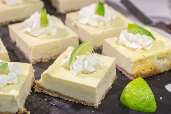 Featuring a hint of tequila + lime flavor in a creamy cheesecake filling, these Margarita Cheesecake Bars are a fun and tasty summer dessert recipe!
