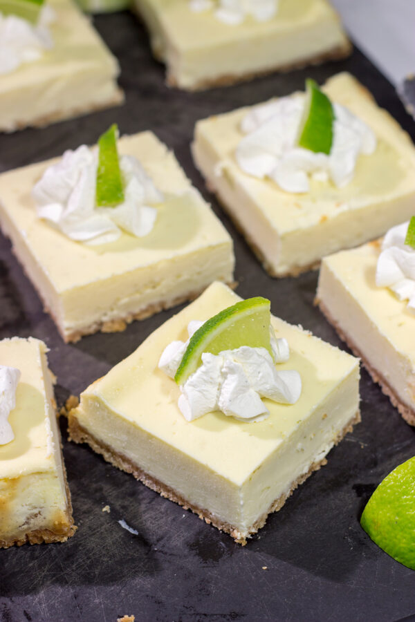 Featuring a hint of tequila + lime flavor in a creamy cheesecake filling, these Margarita Cheesecake Bars are a fun and tasty summer dessert recipe!