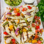 These Pineapple Margarita Chicken Quesadillas are filled with grilled chicken, pineapples, onions and peppers - and the chicken gets marinated in margarita mix for a fun twist!