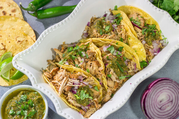 Looking for a good taco recipe? These Slow Cooker Green Chili Tacos are packed with flavor - and they're a real crowd pleaser!