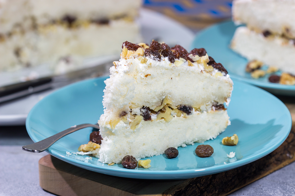 A Lady Baltimore Cake features white cake topped with 2 frostings, toasted walnuts and sherry-soaked raisins. It's truly a unique dessert!