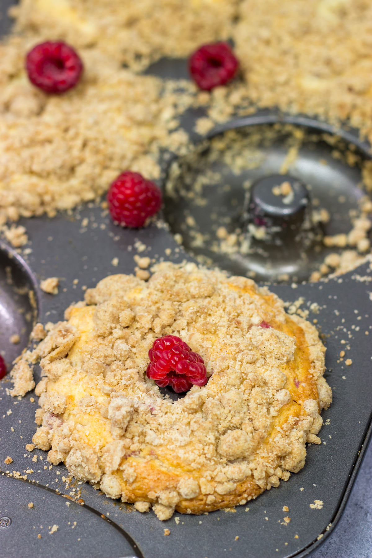 These baked Raspberry Crumb Donuts feature a cake-like base filled with fresh raspberries...and then topped with a thick layer of brown sugar crumble. They're delicious!