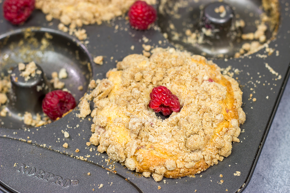 These baked Raspberry Crumb Donuts feature a cake-like base filled with fresh raspberries...and then topped with a thick layer of brown sugar crumble. They're delicious!