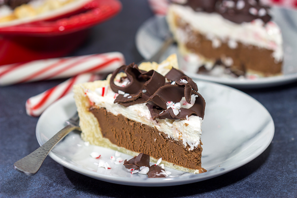 Topped with creamy whipped cream and large chocolate curls, this Chocolate Peppermint Pie is a tasty and impressive dessert to serve during the holiday season!