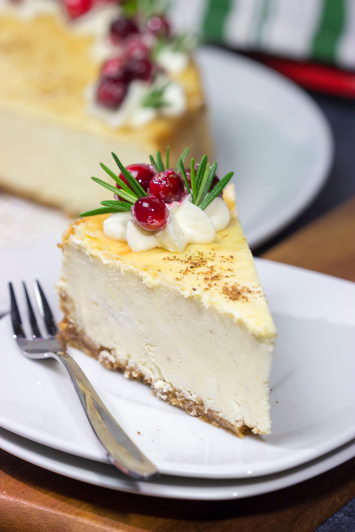 Topped with sugared cranberries and eggnog whipped cream, this Eggnog Cheesecake is a festive way to celebrate the holiday season!