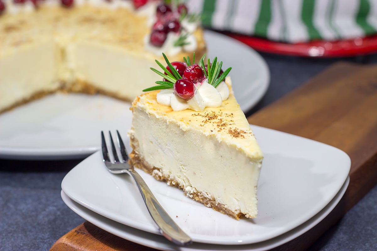 Topped with sugared cranberries and eggnog whipped cream, this Eggnog Cheesecake is a festive way to celebrate the holiday season!
