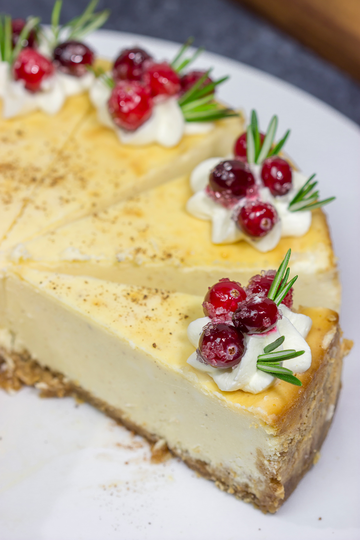 Topped with sugared cranberries and eggnog whipped cream, this Eggnog Cheesecake is a festive way to celebrate the holiday season!