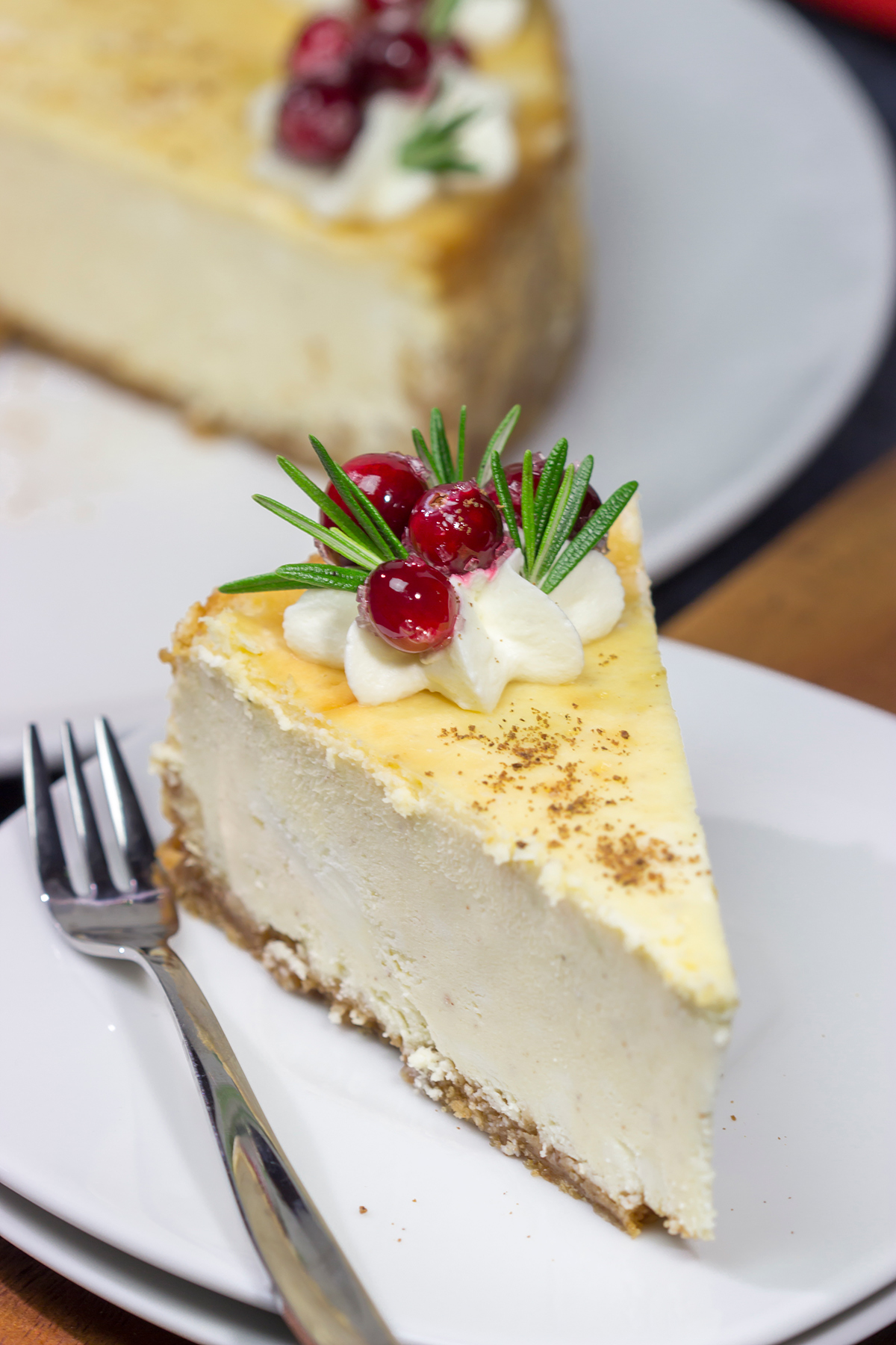 Topped with sugared cranberries and eggnog whipped cream, this Eggnog Cheesecake is a festive way to celebrate the holiday season!