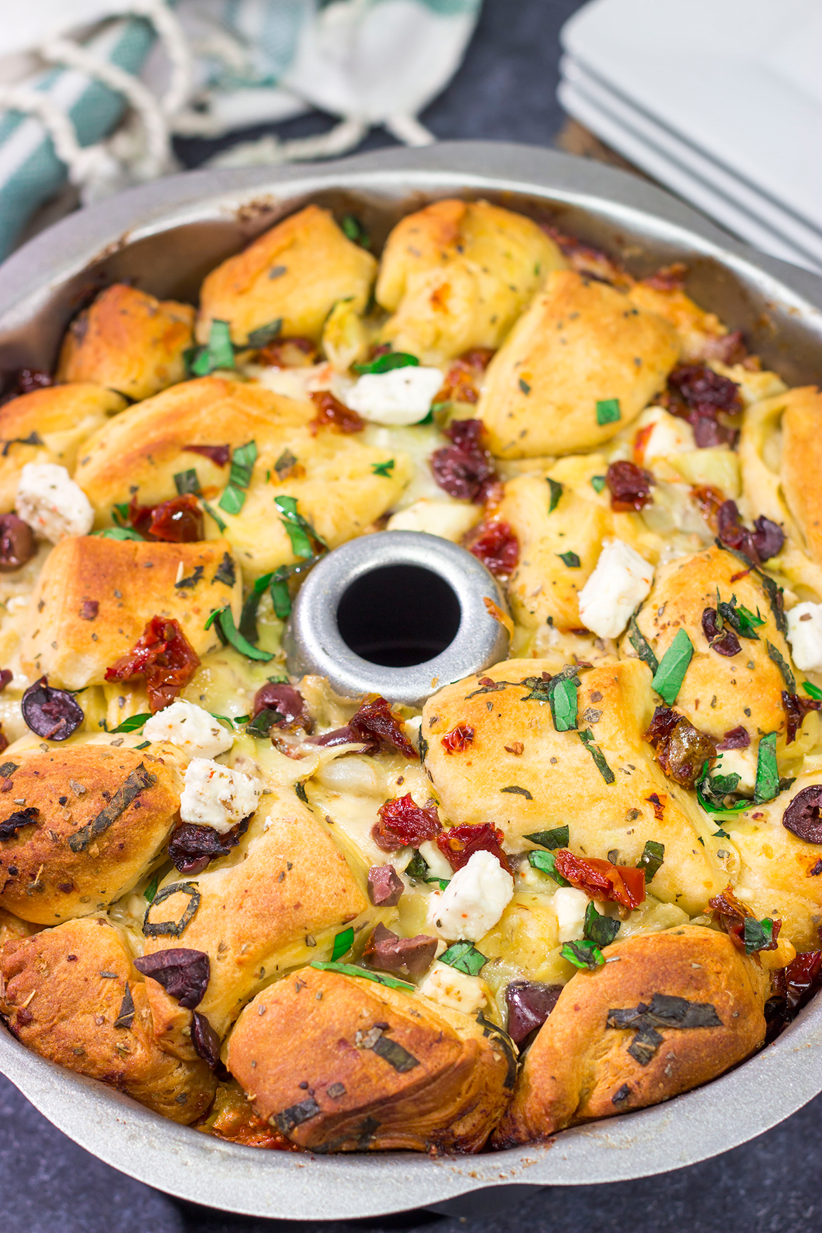 Put a fun spin on monkey bread with this Mediterranean Pull Apart Bread! Think melty cheese, bread, olives, artichokes and sun-dried tomatoes - yum!