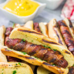 Holy hot dogs, Batman! No need for the oven here. These Grilled Bacon Wrapped Hot Dogs are cooked on the grill and served on a garlic bread buns. Yum!
