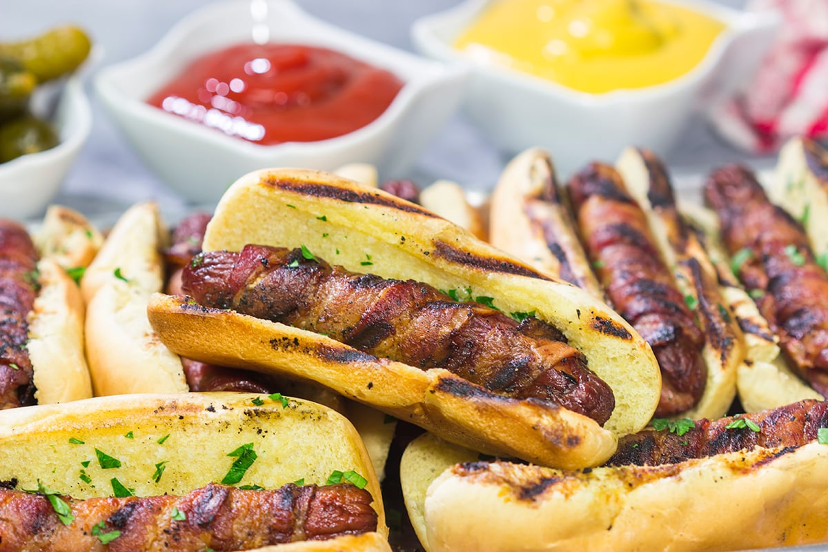 Holy hot dogs, Batman! No need for the oven here. These Grilled Bacon Wrapped Hot Dogs are cooked on the grill and served on a garlic bread buns. Yum!