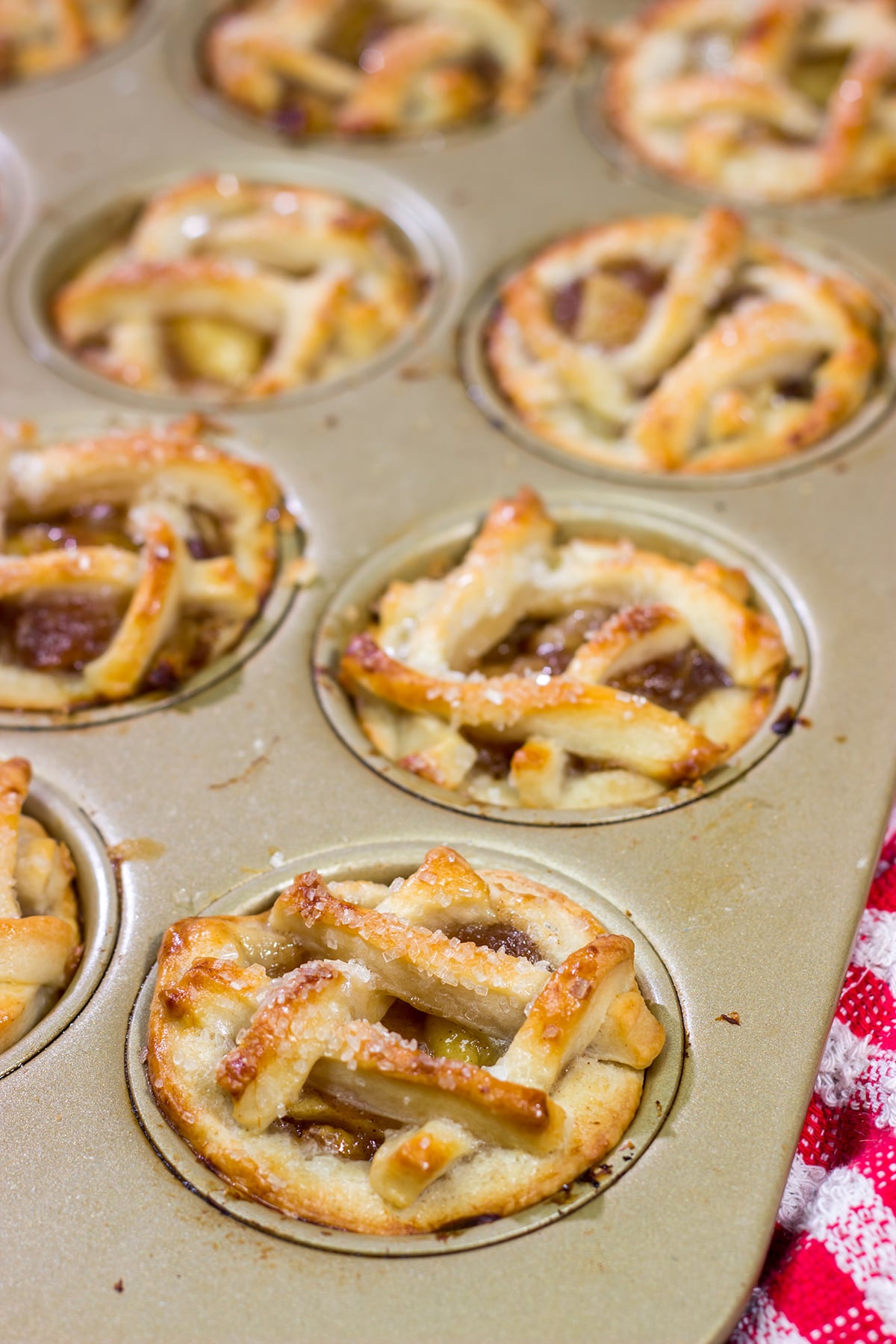 These Mini Apple Pies are baked in a muffin tin for an easy and fun twist on a classic apple pie. Grab some apples at a local orchard and whip up a batch of these pies for dessert!