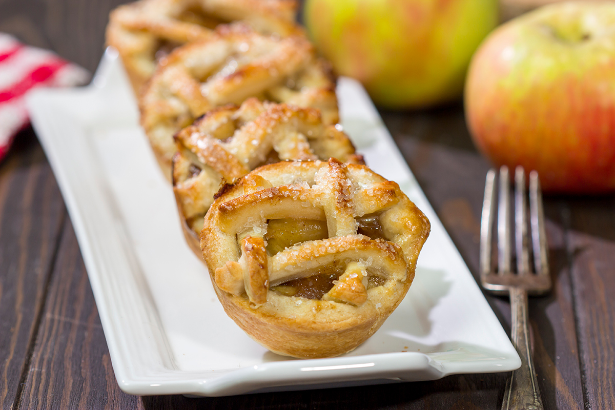 These Mini Apple Pies are baked in a muffin tin for an easy and fun twist on a classic apple pie. Grab some apples at a local orchard and whip up a batch of these pies for dessert!
