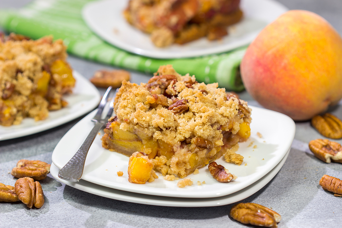 It's fresh peach season! These easy Peach Crumble Bars make for a fantastic summer dessert. Grab some peaches and get a batch of these bars in the oven today!