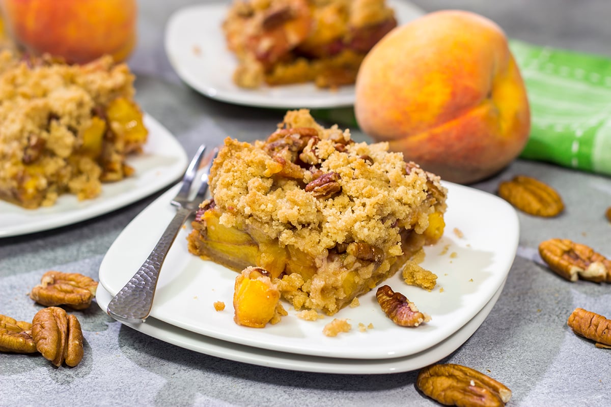 It's fresh peach season! These easy Peach Crumble Bars make for a fantastic summer dessert. Grab some peaches and get a batch of these bars in the oven today!