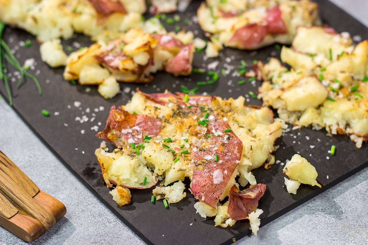 These Ranch Smashed Potatoes feature lots of crispy edges brushed with seasoned butter. These potatoes are perfect for when you need a new side dish recipe!