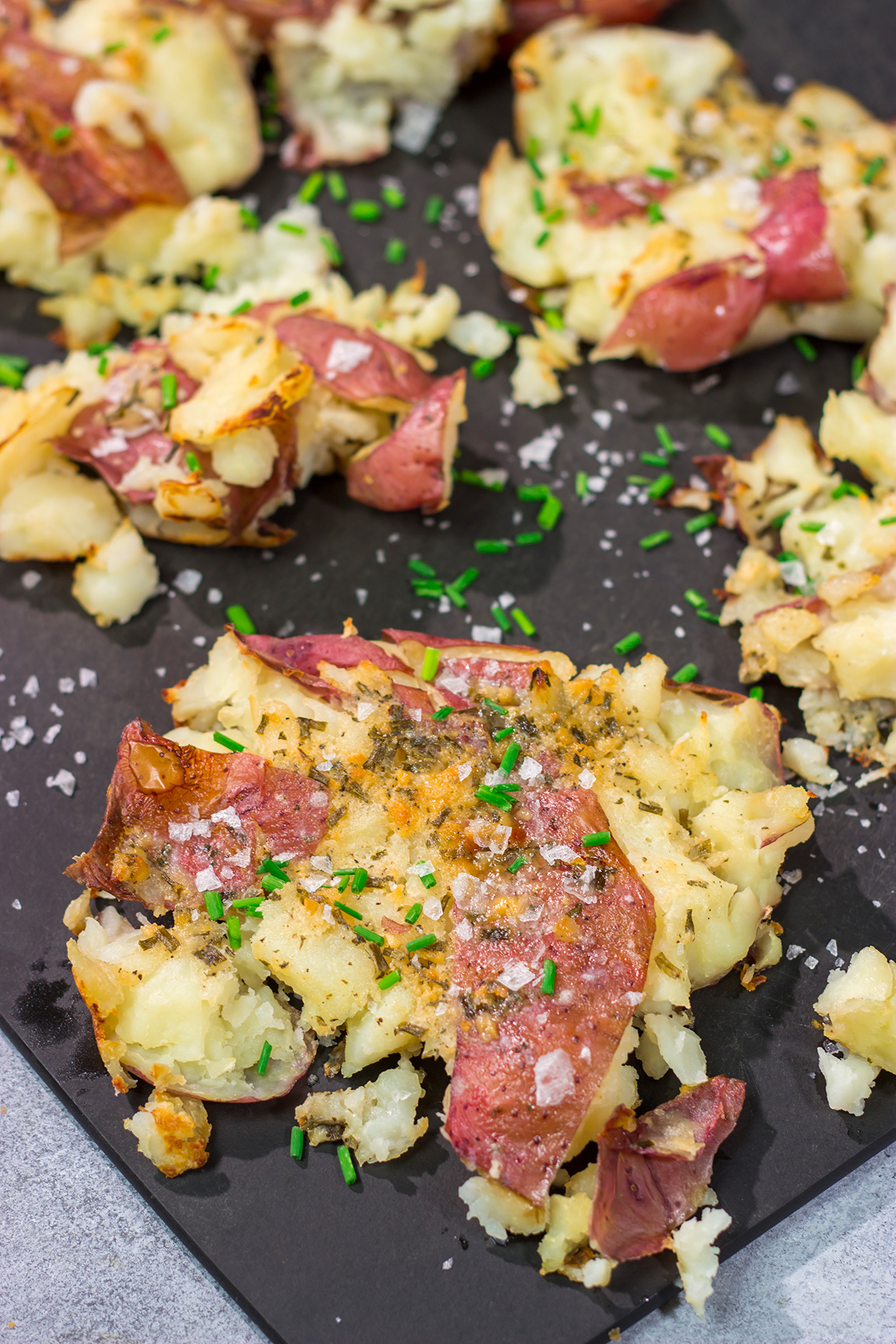 These Ranch Smashed Potatoes feature lots of crispy edges brushed with seasoned butter. These potatoes are perfect for when you need a new side dish recipe!