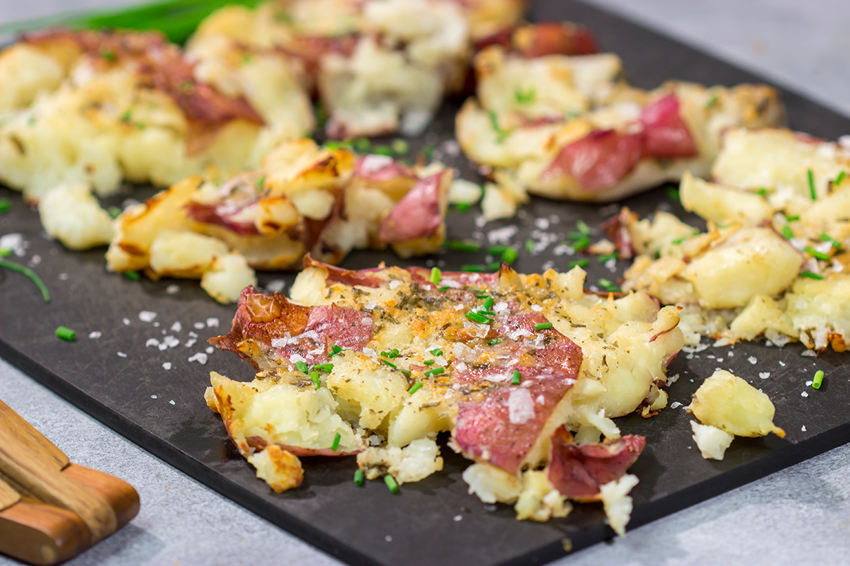 These Ranch Smashed Potatoes feature lots of crispy edges brushed with seasoned butter. These potatoes are perfect for when you need a new side dish recipe!