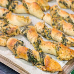 Looking for a tasty gameday appetizer? These Spinach Artichoke Breadsticks are a combination of garlic knots + spinach artichoke dip. They're delicious!
