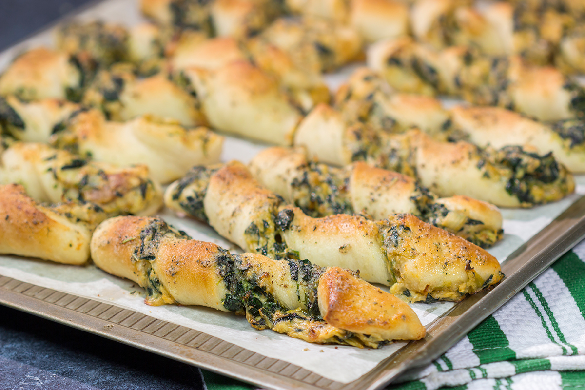 Looking for a tasty gameday appetizer? These Spinach Artichoke Breadsticks are a combination of garlic knots + spinach artichoke dip. They're delicious!